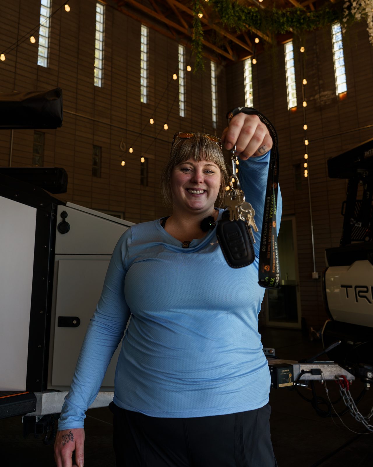 A smiling winner holding up the keys to her prize on winner day